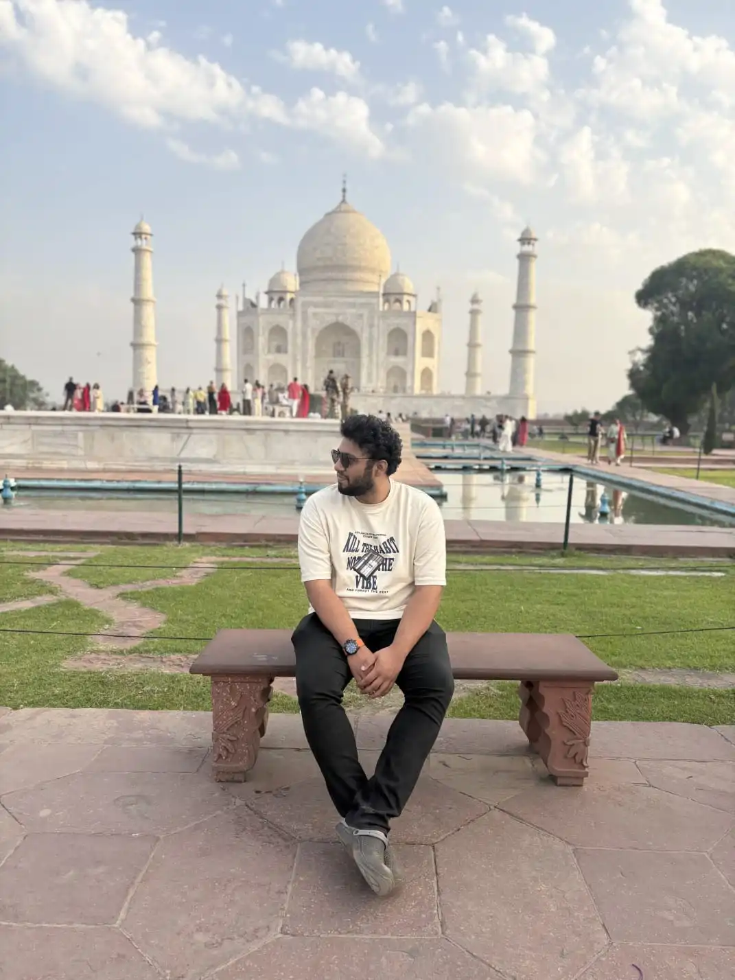 Raghavendra sitting on a bench in front of the Taj Mahal